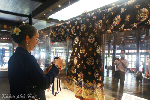 Du khách tham quan chụp hình cổ vật áo dài Nhật bình