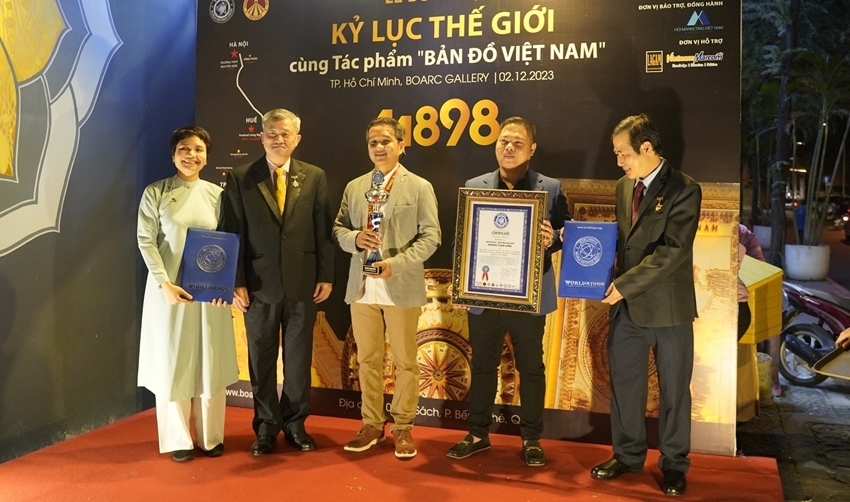  Handing over two records on creating the artwork to Hoang Tuan Long, the architect (middle)