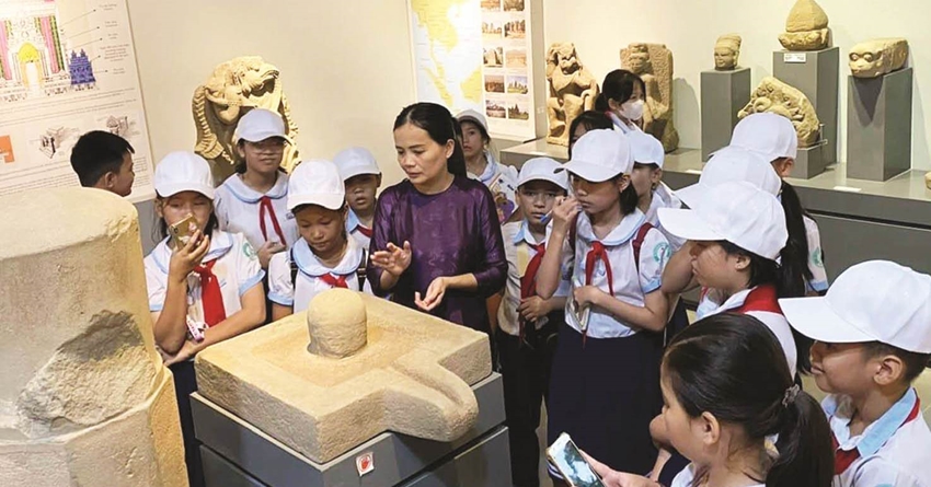Các em học sinh nghe thuyết minh về cổ vật Chăm ở Bảo tàng Cổ vật Cung đình Huế