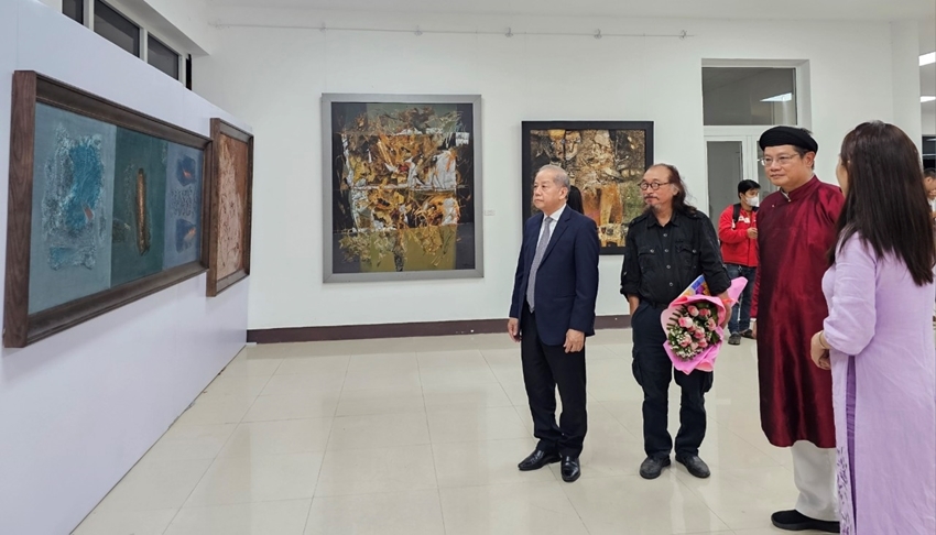  Permanent Deputy Secretary of the Provincial Party Committee Phan Ngoc Tho (on the left) was looking at the paintings at the exhibition