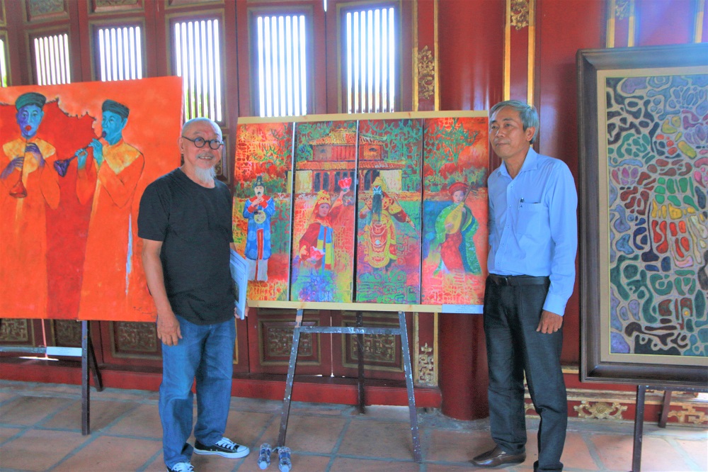 The authors take photos with works displayed at the exhibition