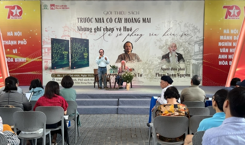 The author and journalist Minh Tu (standing) talking to Hanoi readers. Photo: T. Long