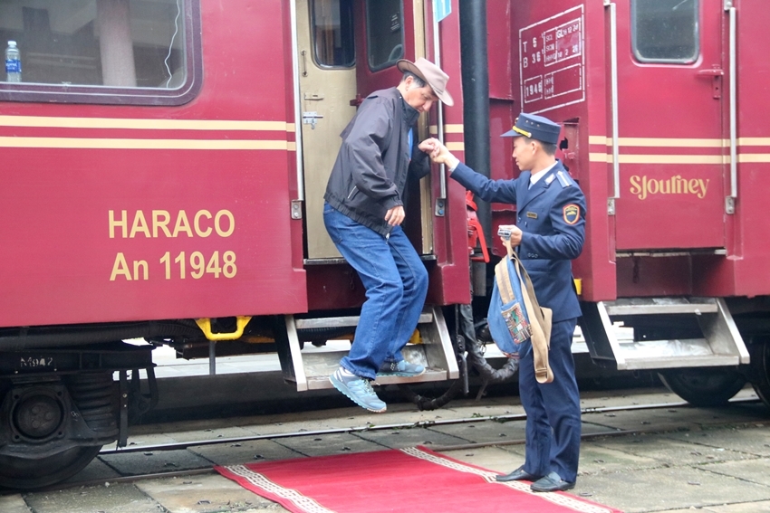 The station staff assisting the passengers to get off the train