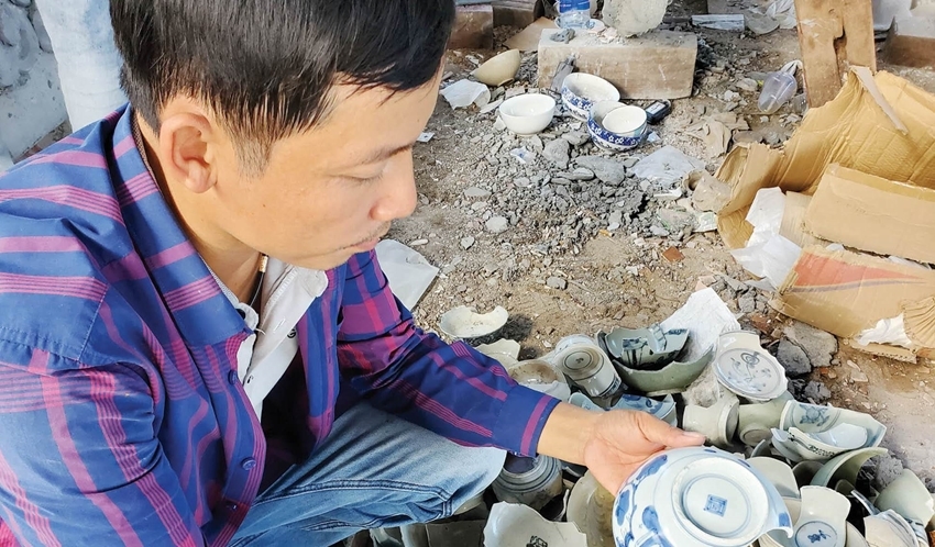  Artisan Nguyen Thanh Thuan by the broken bowls purchased for the ceramic mosaic to restore dragons and phoenixes at Thai Hoa Palace. Photo: Bui Ngoc