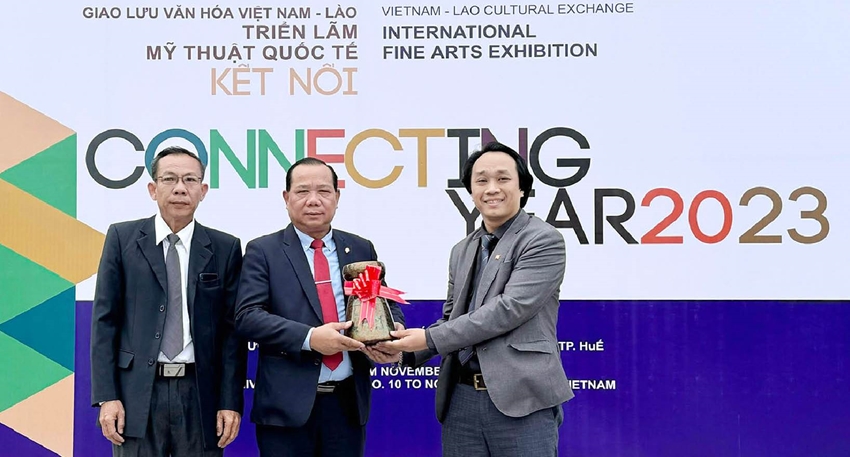  TS. Phan Lê Chung, Chủ tịch Hội đồng Trường đại học Nghệ thuật, Đại học Huế (bên phải) tặng quà cho đại diện Trường Mỹ thuật Savannakhet Lào tại triển lãm ở Huế