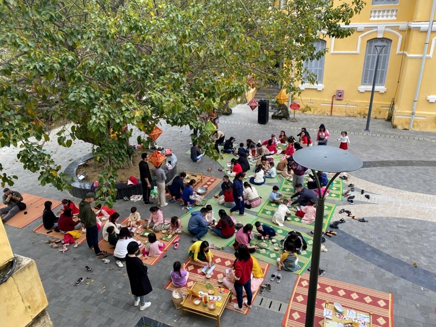  Children and their parents participating in the experience of cooking tet cakes at the space of 23-25 Le Loi