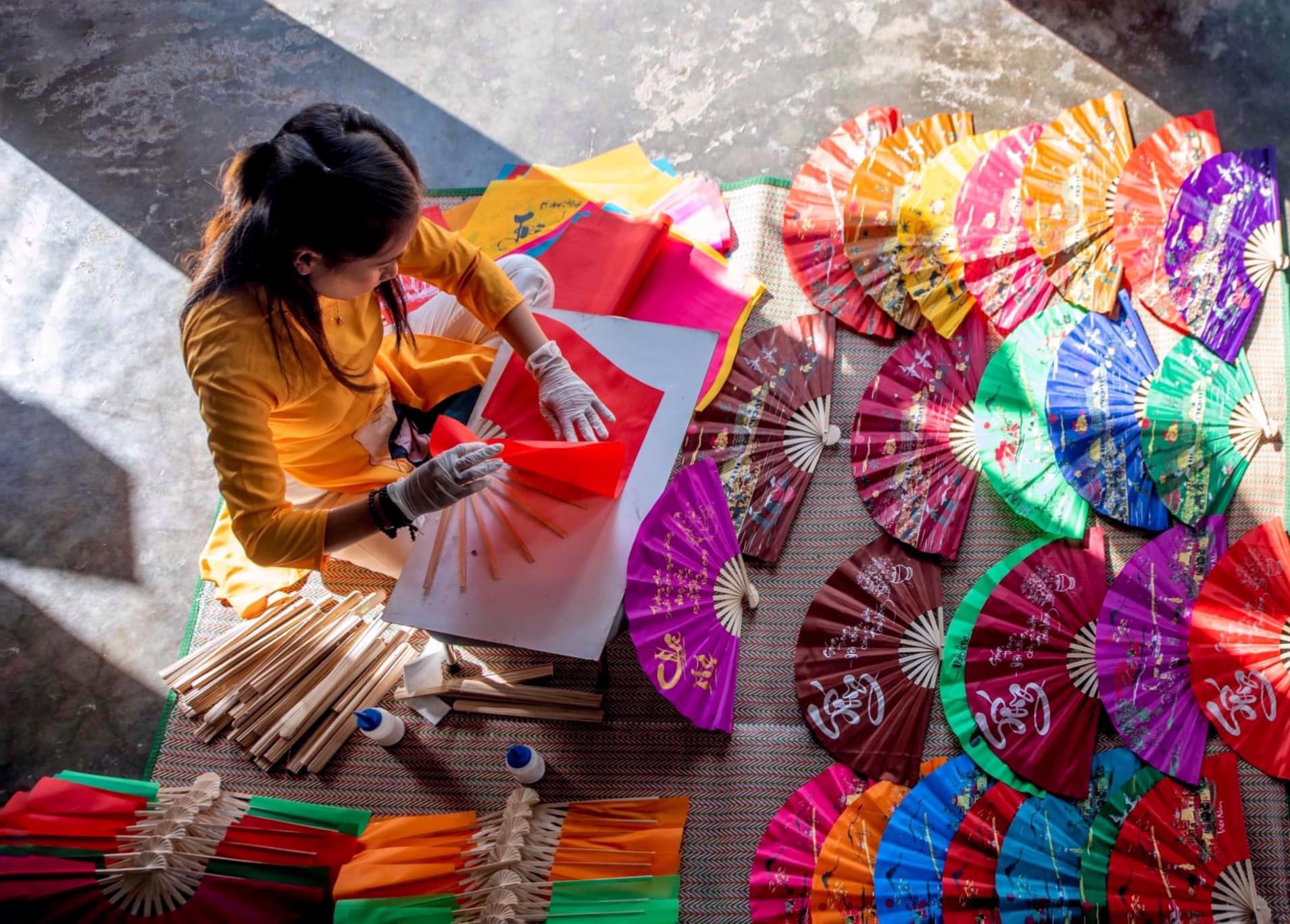 The craftsman is engrossed in the steps to make a paper fan - Photo: Le Van Minh