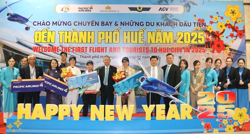 Permanent Vice Chairman Nguyen Thanh Binh presenting flowers and posing for commemorative photos with passengers