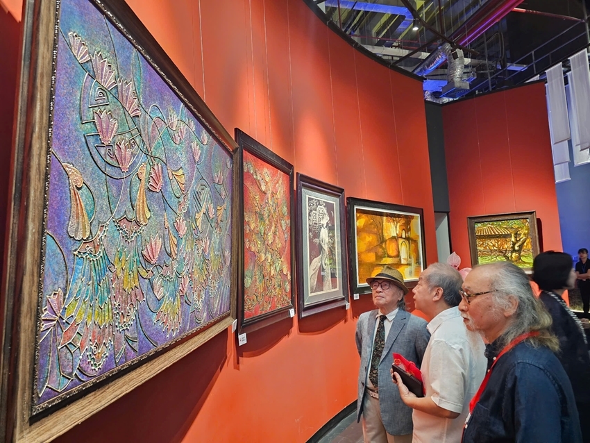 Art lovers contemplating the artworks at the “Loving Hue” exhibition