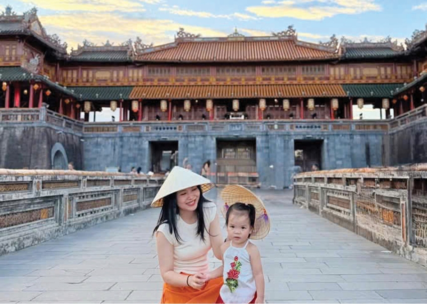  Mẹ con chị Lê Na (Hà Nội) chụp hình cùng nón lá Huế. 