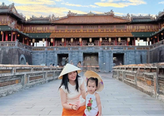  Mẹ con chị Lê Na (Hà Nội) chụp hình cùng nón lá Huế. 
