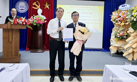 PGS.TS Trần Kiêm Hảo, Giám đốc Sở Y tế thành phố (bìa trái) trao quyết định và tặng hoa chúc mừng ông Nguyễn Khoa Nguyên được bổ nhiệm Giám đốc Bệnh viện Lão khoa - PHCN TP. Huế.  